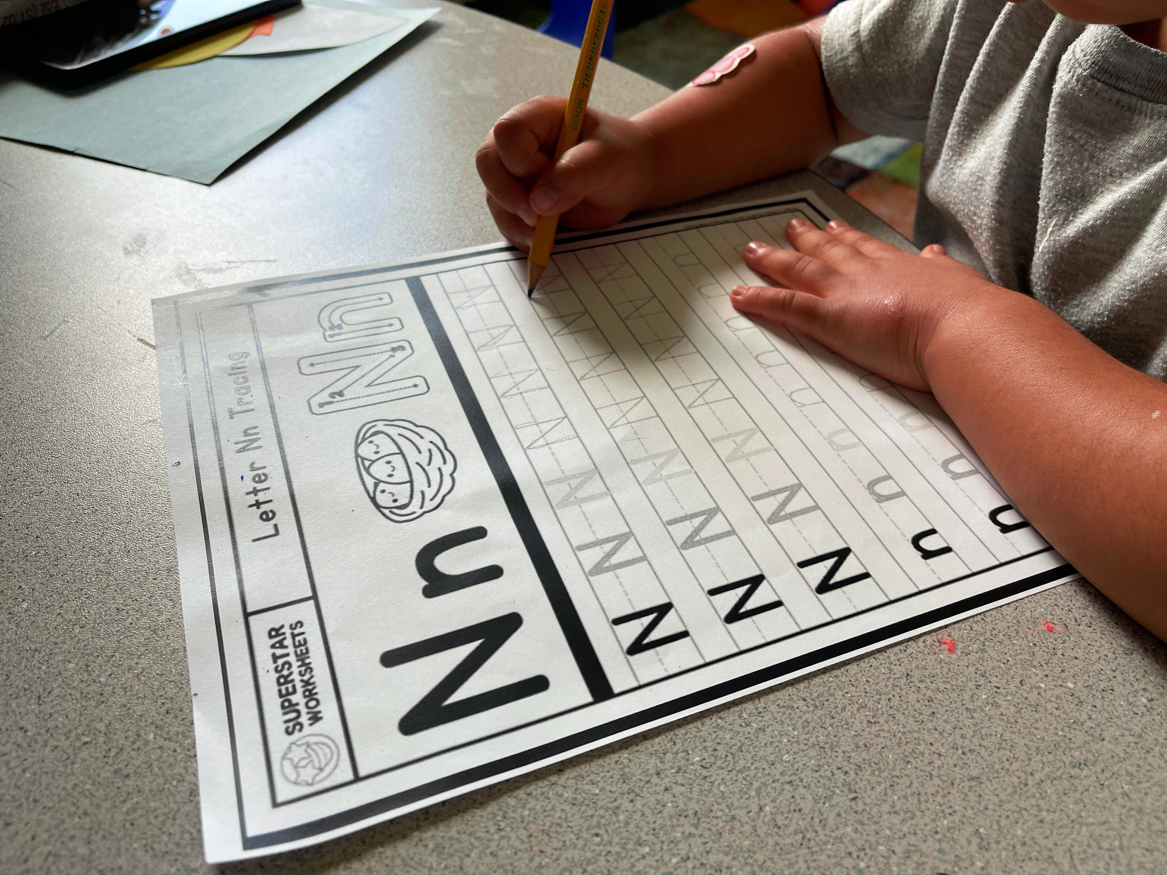 Child tracing letter N at Loving Littles Daycare