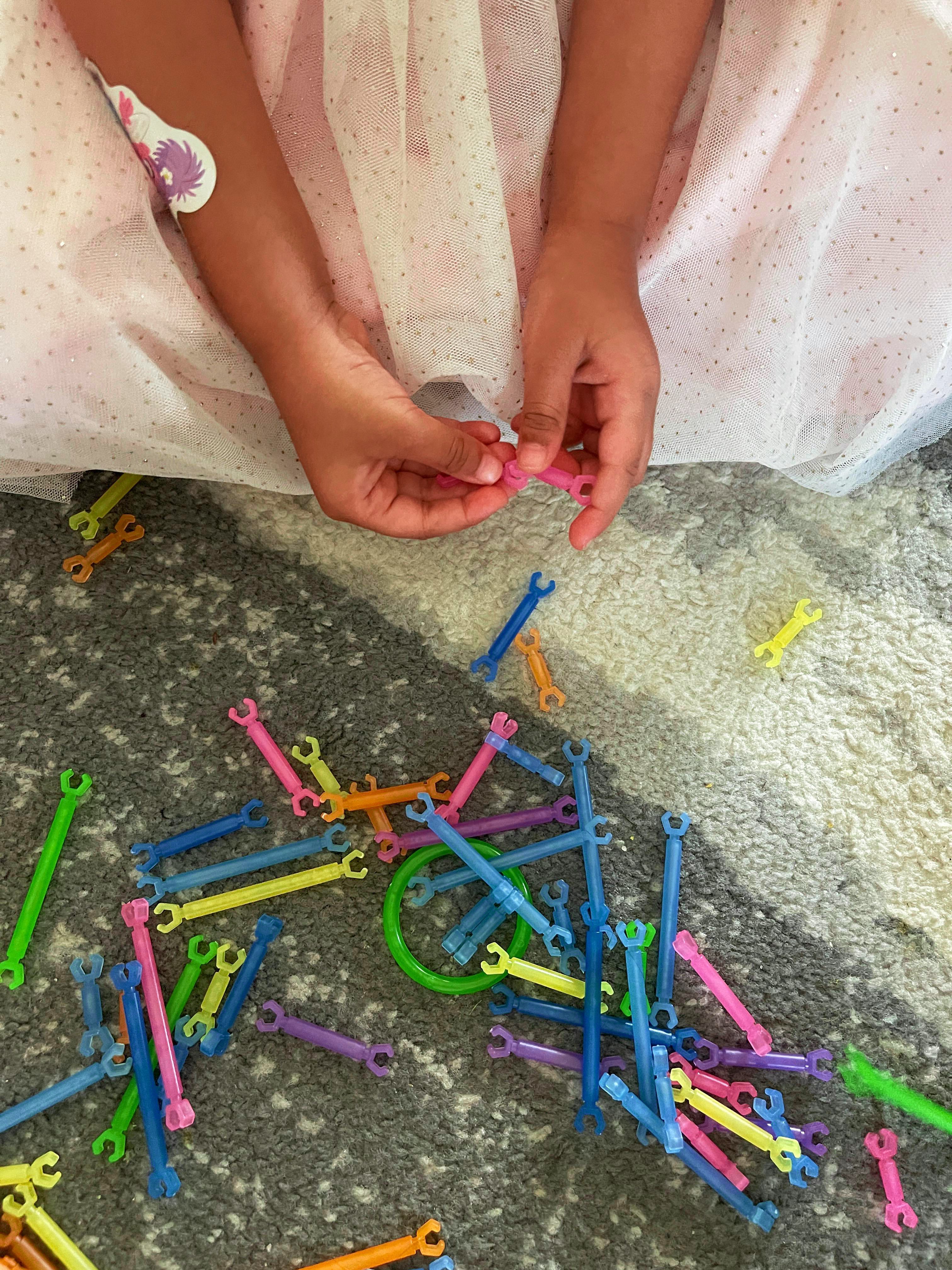 Child playing with building sticks at Loving Littles Daycare